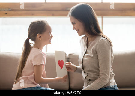 La figlia e la madre seduta sul lettino azienda artigianale di cartolina Foto Stock