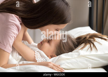 Baci madre figlia mette a dormire nel pomeriggio nap Foto Stock