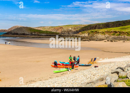 Kayakers del mare su una spiaggia deserta a Whitesands Bay, Il Pembrokeshire Coast National Park, Wales, Regno Unito Foto Stock