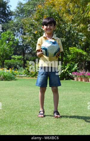 Ragazzo in possesso di un pallone da calcio Foto Stock