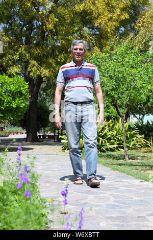 Senior uomo a camminare in un parco Foto Stock