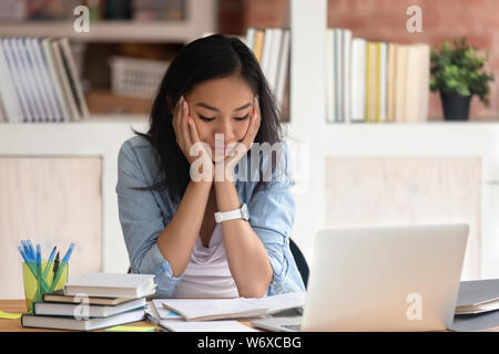 Asian esaurito ragazza studente avente molte attività di cui si sente infelice Foto Stock