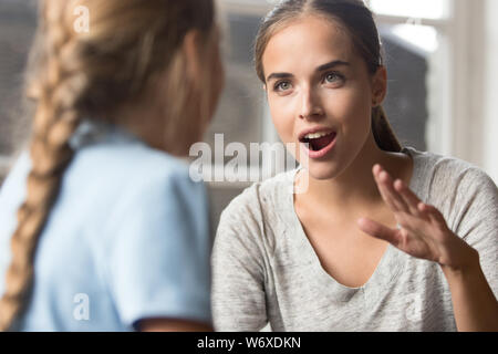 Giovane madre di parlare con la figlia emotivamente gesticulating utilizzando il linguaggio dei segni Foto Stock