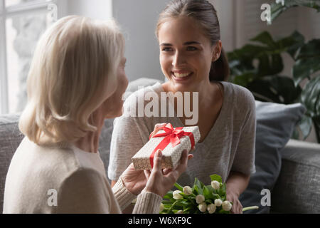 Persone di mezza età madre riceve da cresciuti figlia confezione regalo Foto Stock