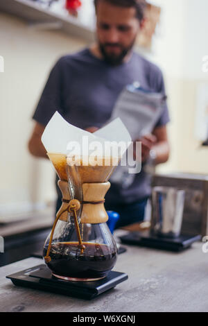 Brewign terza onda caffè con vetro chemex e bollitore antigoccia per puro gusto nel buon design sul tavolo di legno Foto Stock