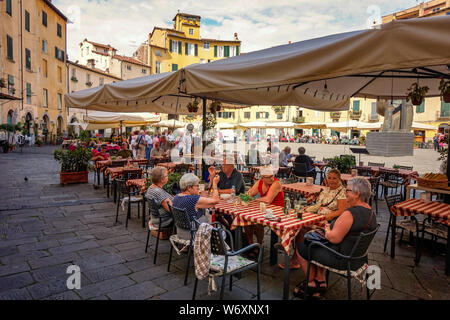Piazza Anfiteatro,Lucca-09.15.2017: gruppo di anziani turisti che si godono la gastronomia della toscana Foto Stock