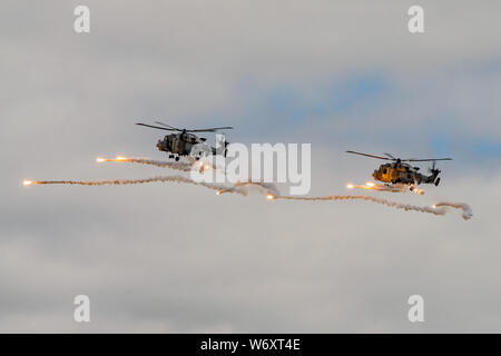 Due Royal Navy Wildcat HMA2 elicotteri iniziano a fuoco un modello di missile decoy flares durante gli RNAS Yeovilton aria giorno, nel Regno Unito il 13 luglio 2019. Foto Stock