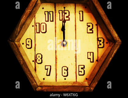 Mezzanotte: Un vecchio orologio in legno in stile retrò appena oltre la mezzanotte esiste in un campo nero vuoto spazio. Foto Stock