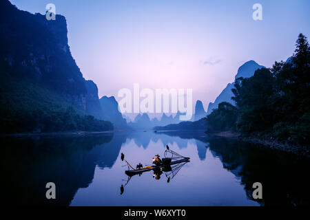 Cormorano tradizionale pescatore, Blackbeard, illuminazione incendio presso sunrise, Xingping, Cina. Foto Stock