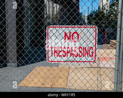 Nessun segno sconfinamenti dietro la catena collegamento recinto blocking off urbano zona di costruzione Foto Stock