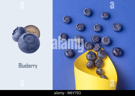 Layout creativo fatto di mirtillo in giallo cono in carta su sfondo blu Foto Stock