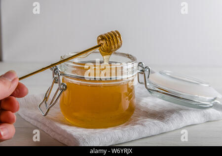 Il miele fresco fognature da cucchiai di miele Foto Stock