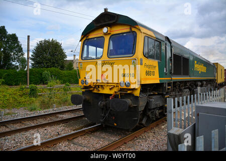 Freightliner classe 66510 locomotiva diesel cale un trasporto merci intermodale di treno sulla linea Birmingham-Peterborough in Cambridgeshire, Regno Unito