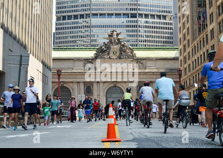 I ciclisti e gli amanti del jogging e pedoni sulla Park Avenue cavalcavia nella parte anteriore del Grand Central Terminal durante il primo giorno della stagione estiva le strade. Foto Stock