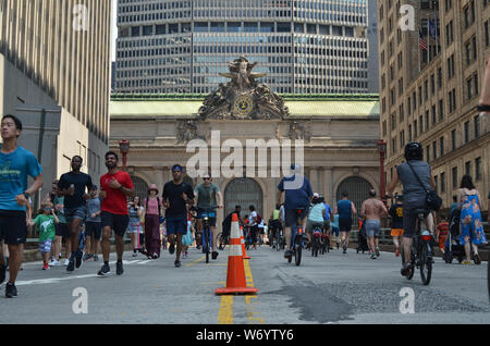 I ciclisti e gli amanti del jogging e pedoni sulla Park Avenue cavalcavia nella parte anteriore del Grand Central Terminal durante il primo giorno della stagione estiva le strade. Foto Stock