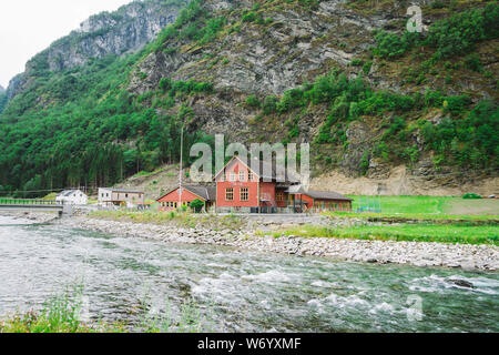 La scuola nel villaggio di Flam in Norvegia. Flam villaggio in Flamsdalen, estremità interna di Aurlandsfjorden, ramo Sognefjorden. Scuola di legno vicino al fiume in montagna Foto Stock