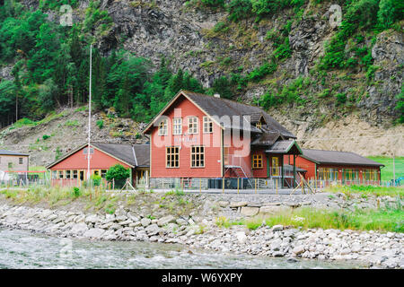 La scuola nel villaggio di Flam in Norvegia. Flam villaggio in Flamsdalen, estremità interna di Aurlandsfjorden, ramo Sognefjorden. Scuola di legno vicino al fiume in montagna Foto Stock