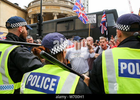 Gli ufficiali di polizia si scontrano con i sostenitori del britannico di estrema destra Stephen Yaxley-Lennon durante la protesta.un rally a sostegno del britannico di estrema destra Yaxley-Lennon Stephen, noto anche come Tommy Robinson nel centro di Londra. Tommy Robinson era stato imprigionato il 11 luglio 2019 presso Old Bailey per disprezzo della corte. Foto Stock