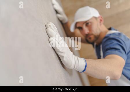 Le piastrelle di ceramica installata perfettamente. Rimodellamento del bagno in modo giusto. Costruzione caucasica lavoratore assicurandosi che le piastrelle parete è perfettamente omogeneo. Foto Stock