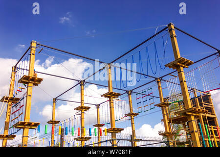 Un frammento di un parco giochi per bambini contro un luminoso cielo blu. Foto Stock