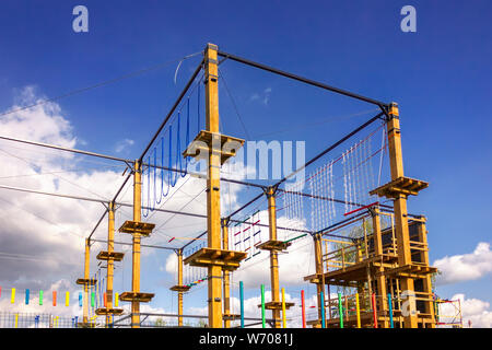 Un frammento di un parco giochi per bambini contro un luminoso cielo blu. Foto Stock