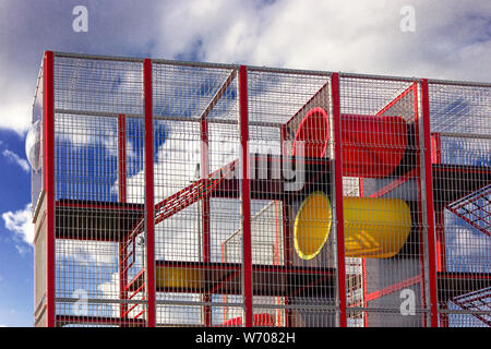 Un frammento di un parco giochi per bambini contro un luminoso cielo blu. Foto Stock