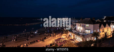 Lyme Regis, Dorset, Regno Unito. Agosto 2019. Meteo REGNO UNITO: folle raccogliere in una calda serata estiva per guardare annuale di agosto di fuochi d'artificio presso il porto di Cobb Lyme Regis. La Carità evento avviene ogni anno come parte della regata, il Carnevale e la scialuppa di salvataggio settimana ed è frequentato da gente del posto e i visitatori della città con molti ritornando di anno in anno. Credito: Celia McMahon/Alamy Live News. Foto Stock