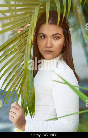 Ritratto di giovane donna HIPANIC su albero di sfondo in foglia Foto Stock