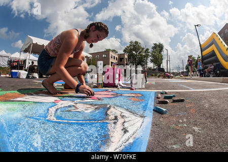 Sandy Springs, GA, Stati Uniti d'America - 22 Settembre 2018: una ragazza adolescente trae chalk arte sul pavimento in un chalk concorso artistico a Sandy Springs Festival. Foto Stock