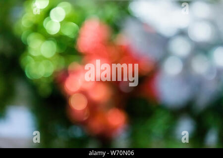 Vacanze di Natale e la festa a tema bokeh di fondo con uno sfondo rosso e verde, oro e argento brilla Foto Stock