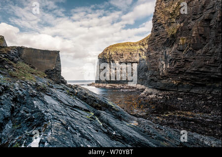 Scogliere ripide rocce e proteggere l'ingresso al porto Whaligoe vicino a stoppino in Caithness in Scozia Foto Stock