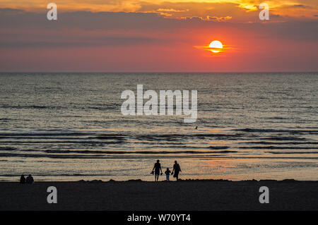 Familiy la sera la spiaggia al tramonto Foto Stock