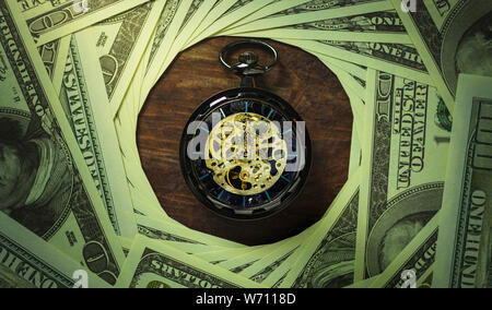 Orologio da tasca e il dollaro di impilamento delle banconote nelle tenebre dello sfondo. Concetto di tempo è denaro o Business. Foto Stock