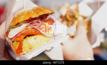 Hamburger di manzo servita sul cibo in stallo sulla cucina aperta International Food festival caso di cibo di strada Foto Stock