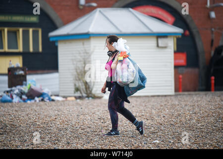 Brighton, Regno Unito. 4 agosto 2019. Un esercito di volontari e lavoratori del consiglio pulizia spiaggia di Brighton e dal lungomare la mattina presto il dopo l annuale Pride Parade attraverso la città . Migliaia di visitatori stanno frequentando il Brighton e Hove Pride eventi nel corso di questo fine settimana . Credito: Simon Dack/Alamy Live News Foto Stock