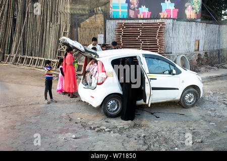 Famiglia indiana persone madre padre bambino mantenendo e pick up oggetto all'interno di eco auto accanto alla strada in mattina tempo alla città di Delhi il 18 marzo 2019 ho Foto Stock