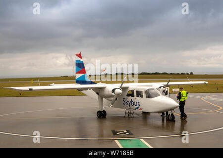 Regno Unito, Inghilterra, Cornwall, Sennen, Land's End aeroporto, equipaggio a terra a Isole Scilly Skybus aeromobili al grembiule in tempesta di pioggia Foto Stock