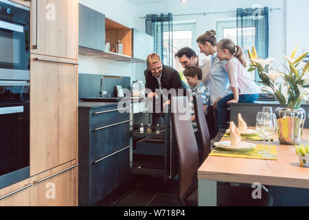 Famiglia con bambini in cerca di una cucina in showroom Foto Stock