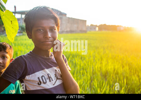 Un ragazzo nepalese e il suo amico al tramonto nel sud del Nepal Foto Stock