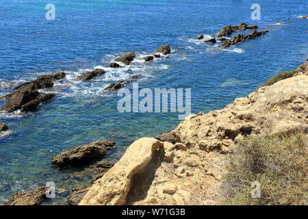 Frastagliate rocce sporgenti dell'Oceano Atlantico vicino alla costa di Albufeira Foto Stock