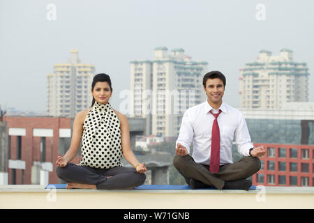 Due dirigenti aziendali in seduta yoga posa Foto Stock