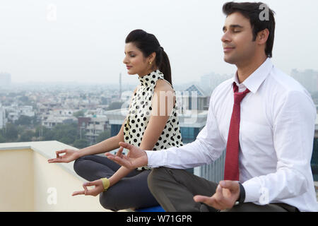 Due dirigenti aziendali in seduta yoga posa Foto Stock