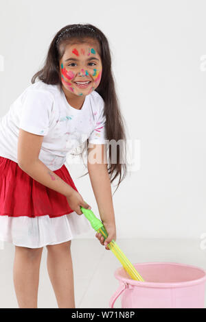 Ragazza che gioca Holi e sorridente Foto Stock