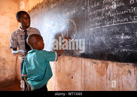 Studenti e insegnanti in una classe di una scuola primaria in un remoto villaggio vicino Ntchisi. Il Malawi è uno dei paesi più poveri del mondo. Foto Stock