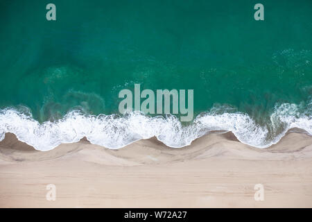 Vista aerea della Skeleton Coast dune di sabbia incontro onde dell oceano Atlanic. Skeleton Coast, Namibia. Foto Stock