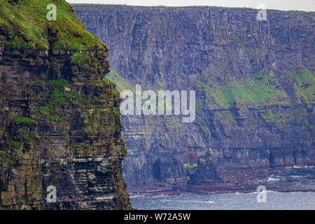 Splendida vista delle pareti verticali delle scogliere di Moher, geosites e geoparco, Wild Atlantic modo meraviglioso nuvoloso giorno di primavera Foto Stock