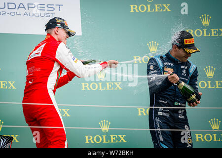 Mick Schumacher (L) di Germania e Sergio Sette Camara del Brasile festeggiare sul podio dopo la seconda gara del campionato FIA di Formula 2 Championship sul circuito di Hungaroring a Budapest. Foto Stock