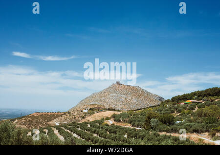 Martos, Provincia di Jaen, Andalusia, Spagna - Giugno 22nd, 2019 : Peña de Martos rock con uliveto in primo piano. Foto Stock