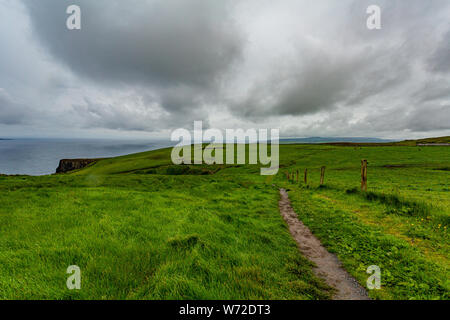 Sentiero rurale tra i campi irlandese da Doolin per le scogliere di Moher lungo la spettacolare percorso costiero a piedi, Wild Atlantic modo, giornata di primavera Foto Stock