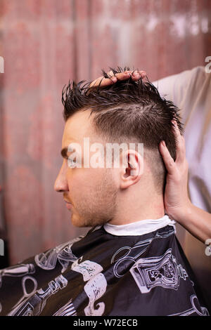 Close up di un maschio di studente avente un taglio di capelli con tosatrici Foto Stock